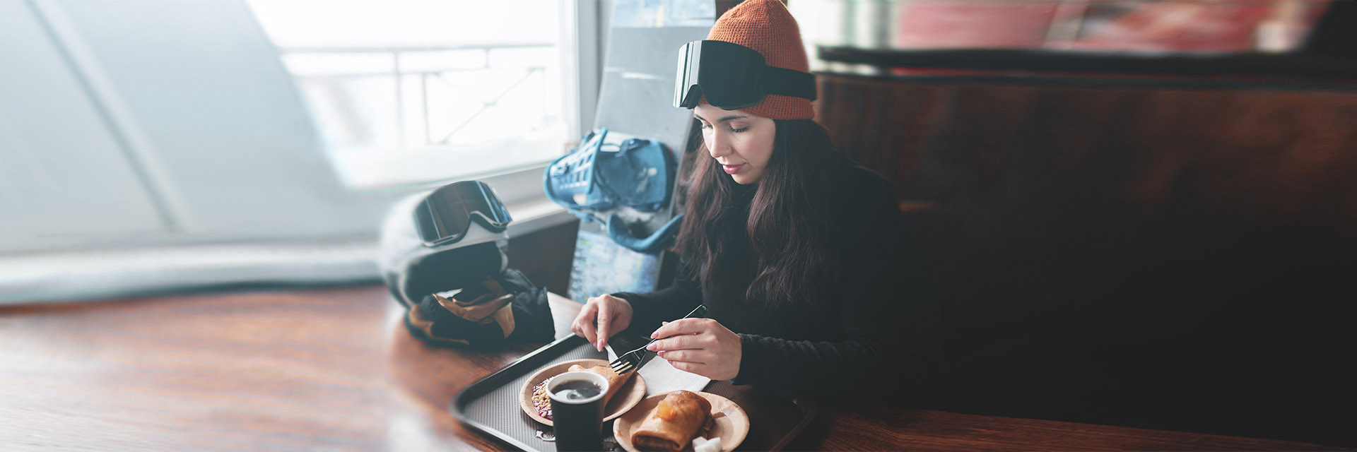 Woman in ski clothes having breakfast