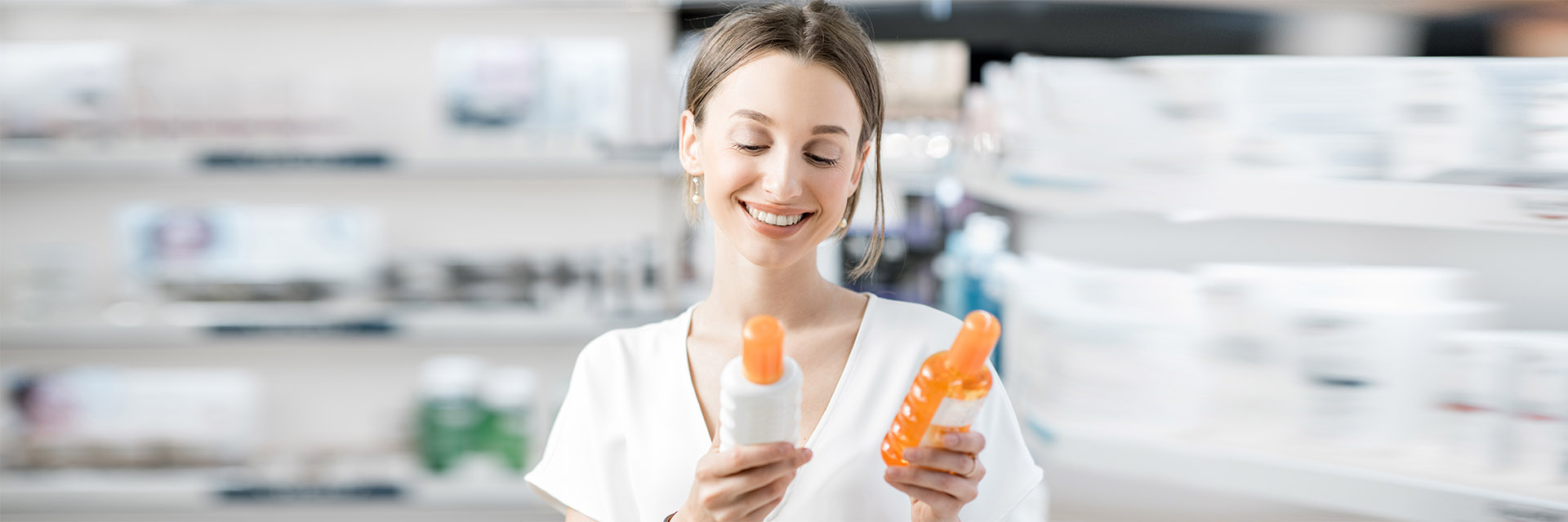 Woman choosing sunscreen at pharmacy
