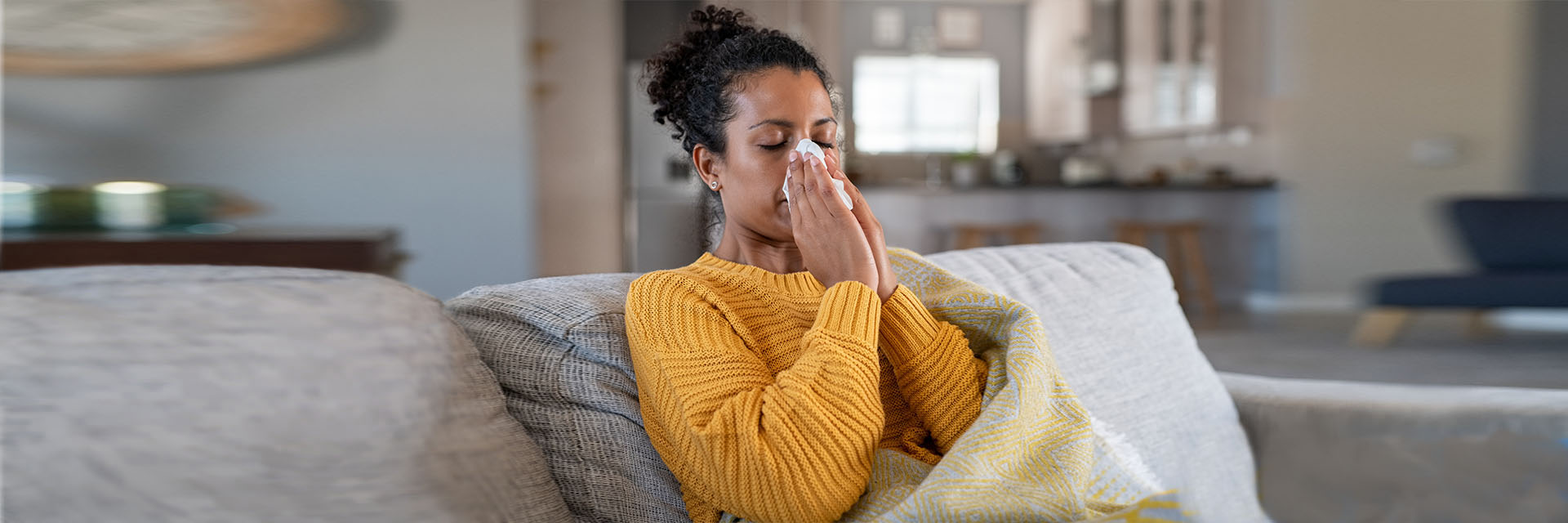 Woman on couch wrapped in a blanket