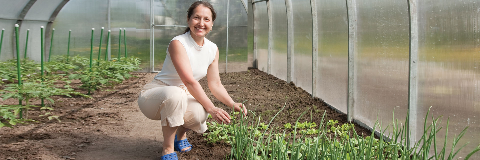 Woman smiling in a greenhouse