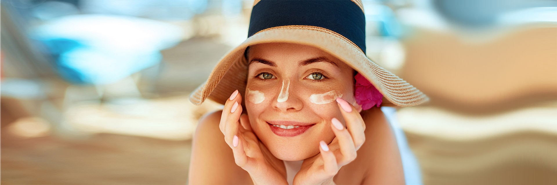 Woman in hat putting on sunscreen