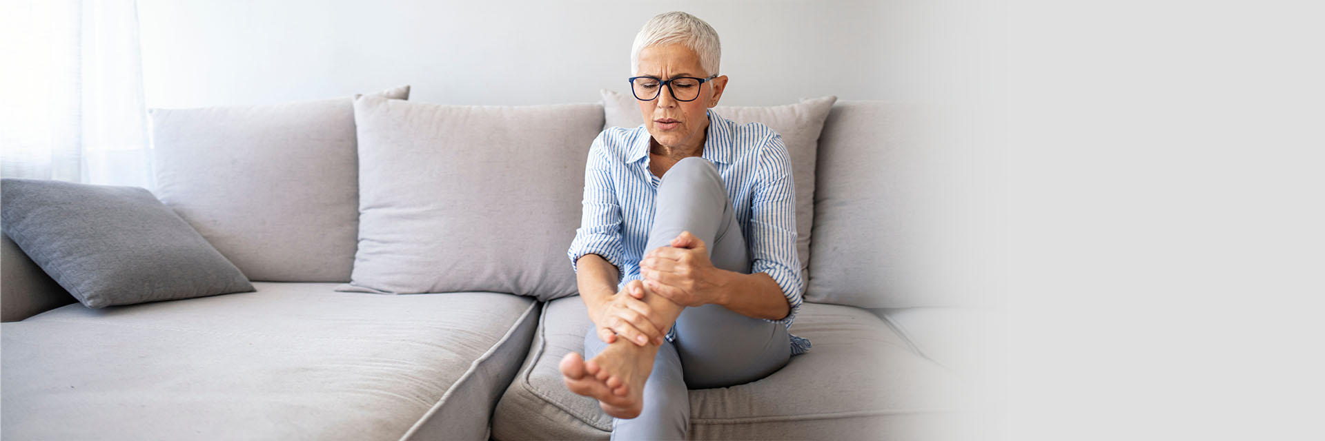 Mature woman rubbing her leg and foot