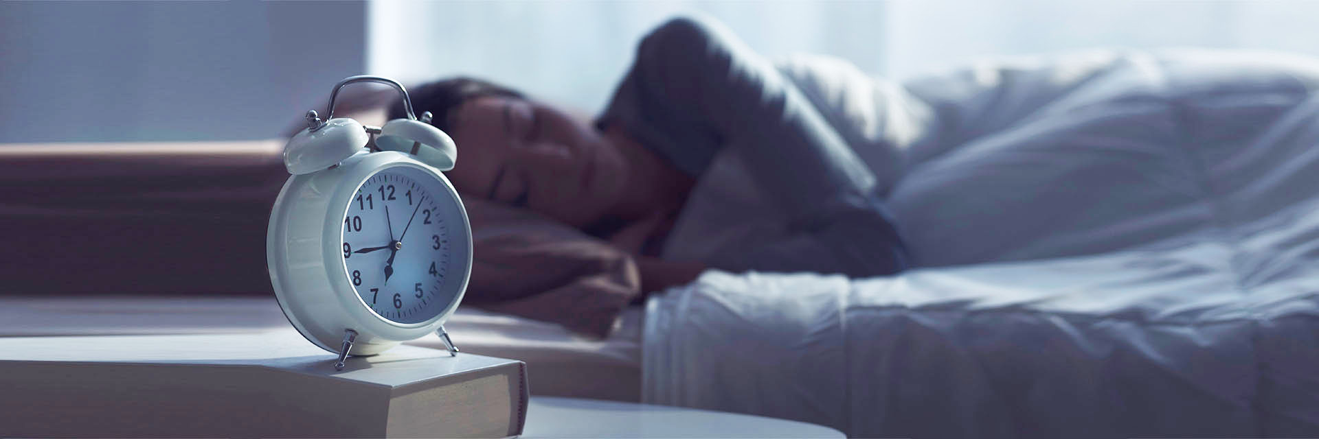 Woman sleeping near her alarm clock