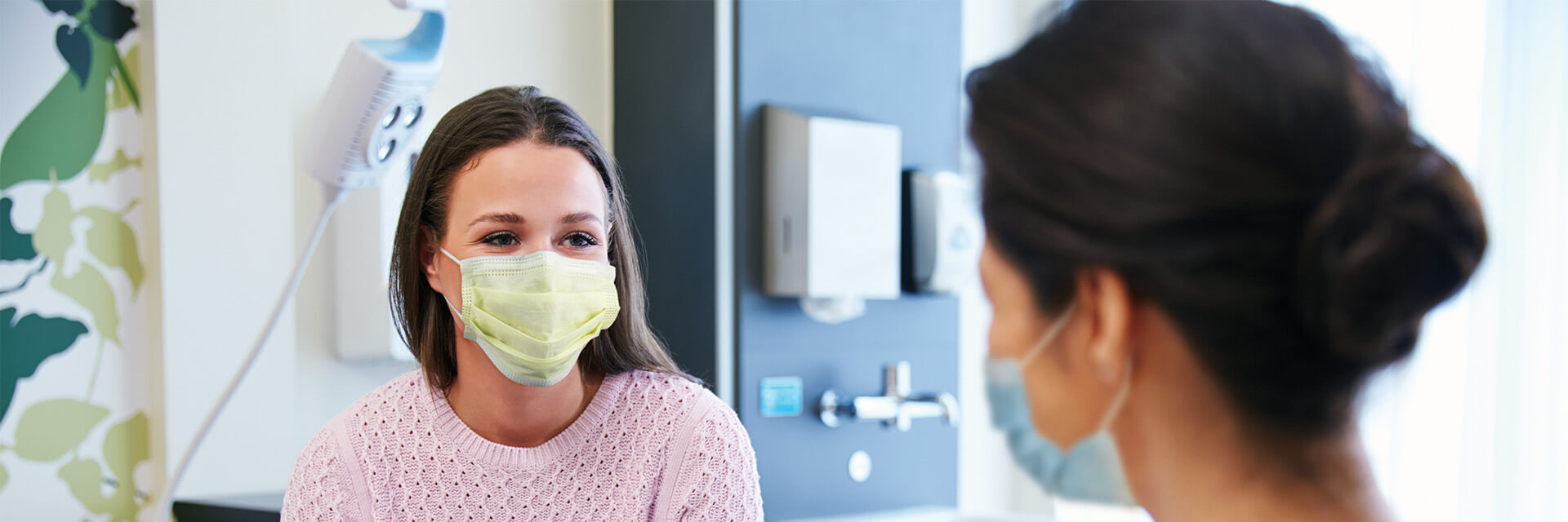 woman talking to her provider while wearing a mask