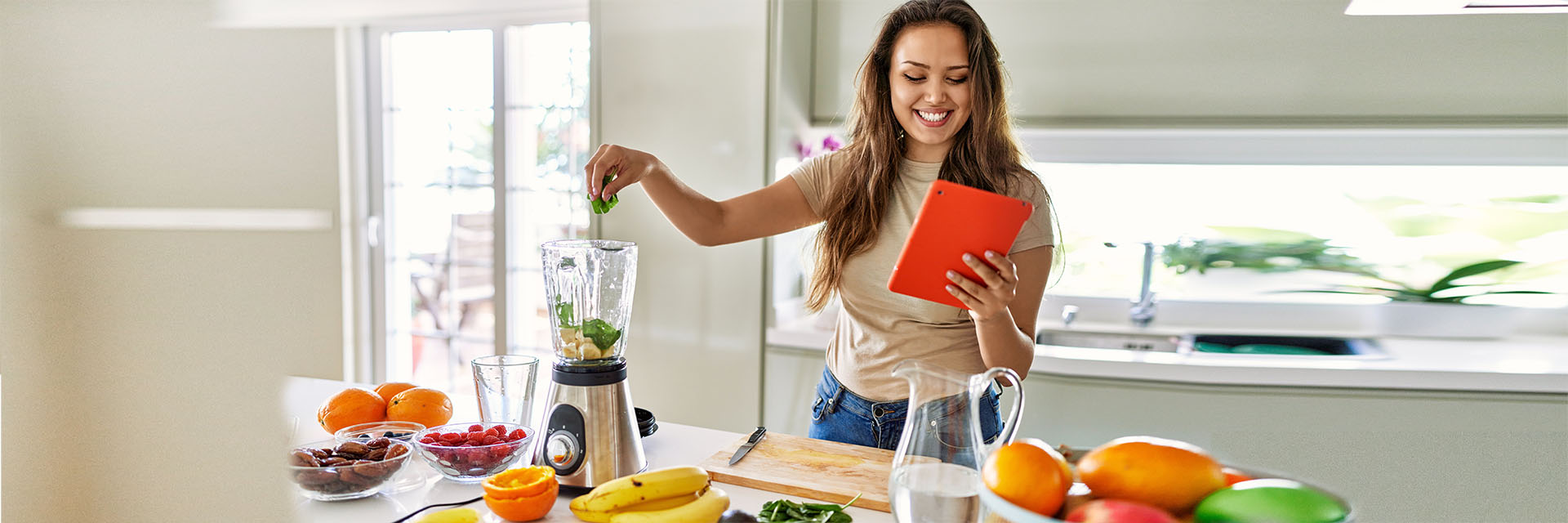 Young woman in kitchen making a smoothie!