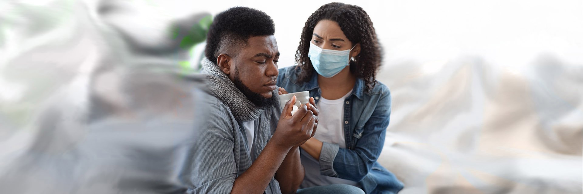 Woman wearing mask comforting sick man