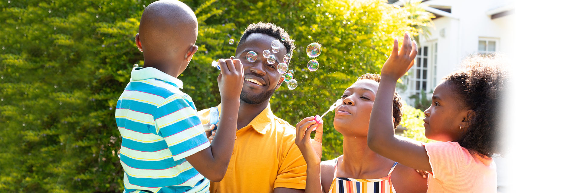 Family blowing bubbles outside