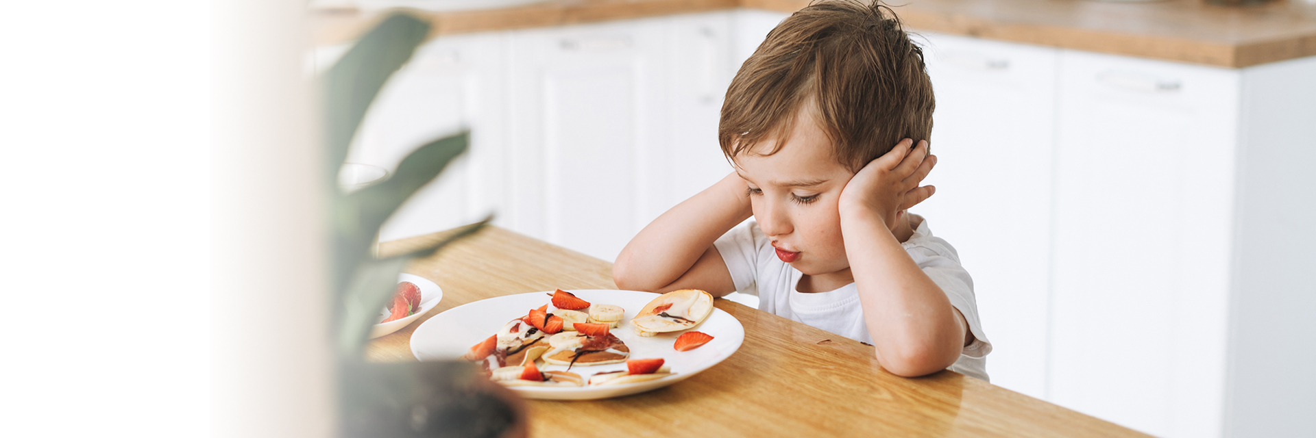Little boy staring at his food
