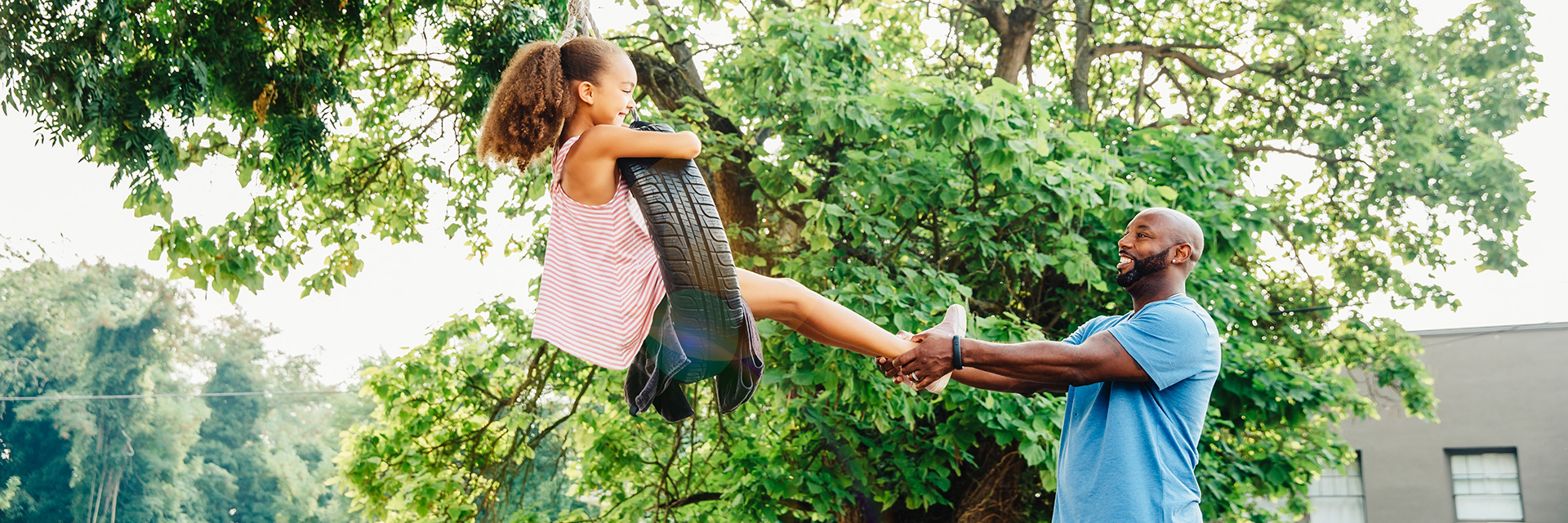 Father and daughter on tire swing