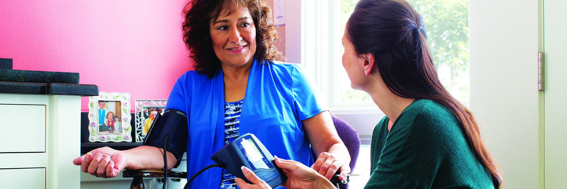 Woman checking blood pressure at home