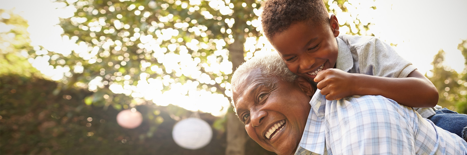 Older man playing with young boy outdoors