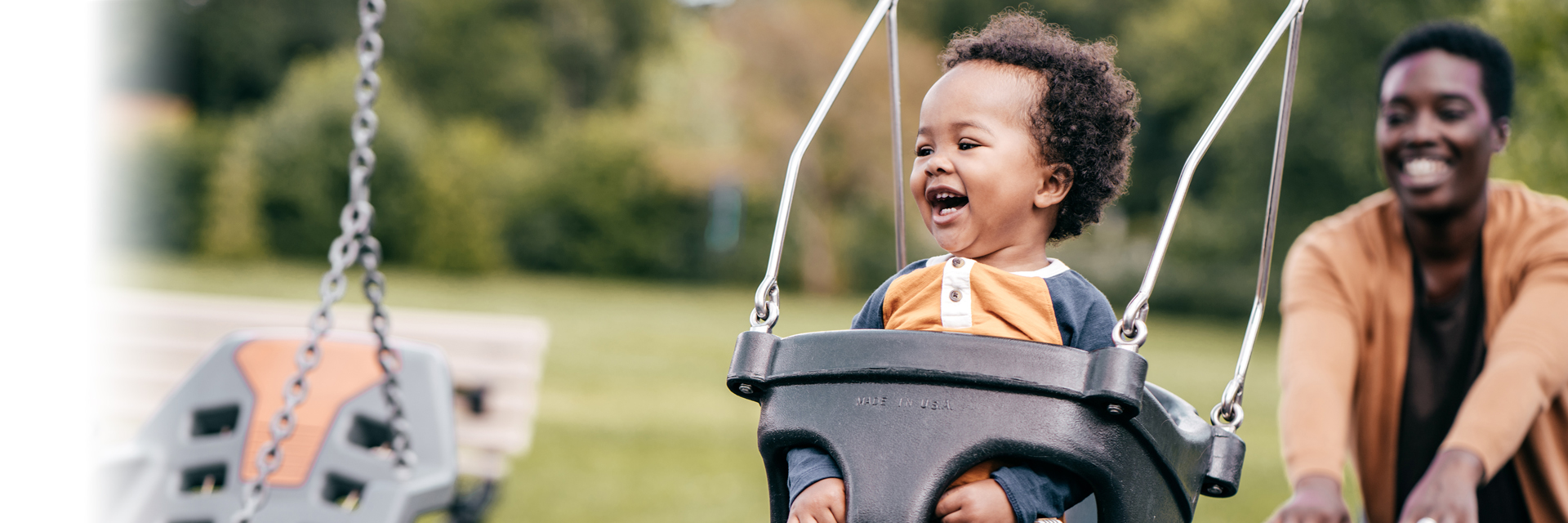 Mom pushing baby in swings