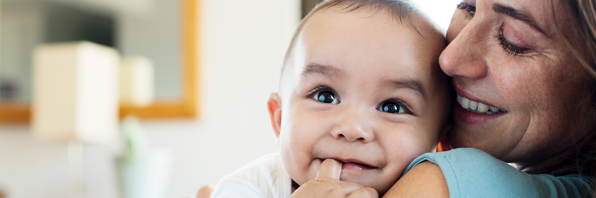 Mom holding smiling baby