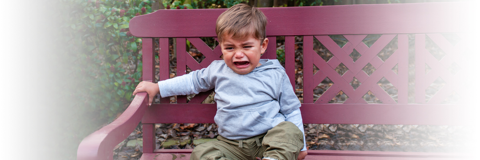Little boy crying on bench