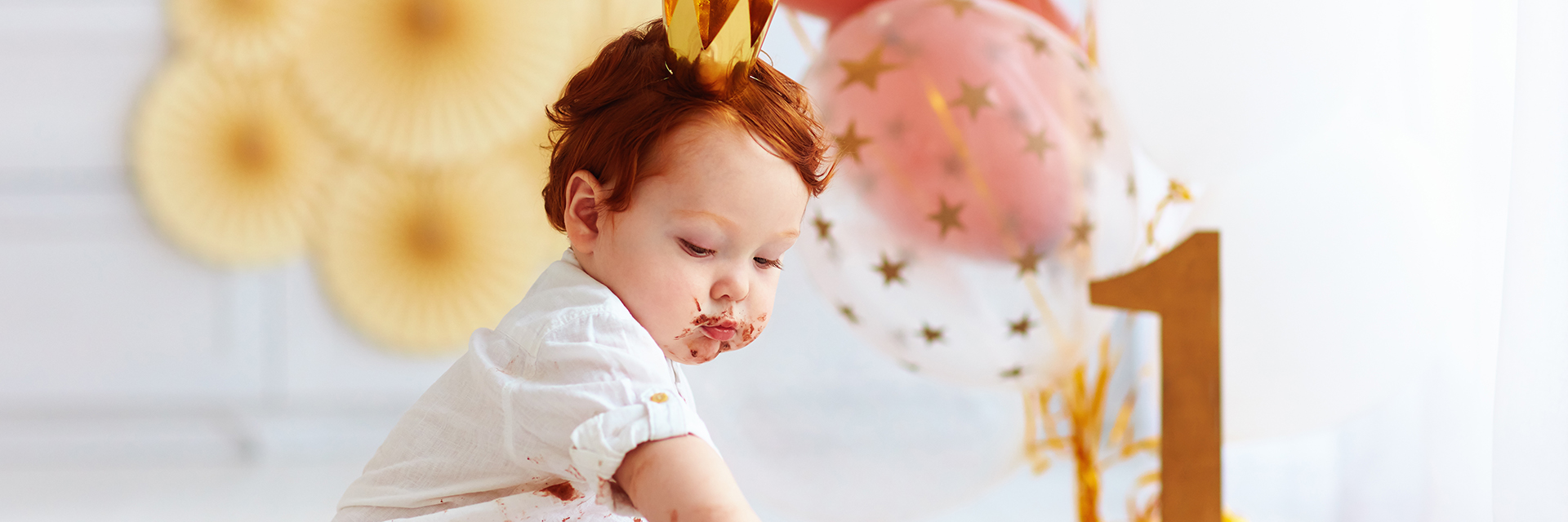 Baby girl eating birthday cake