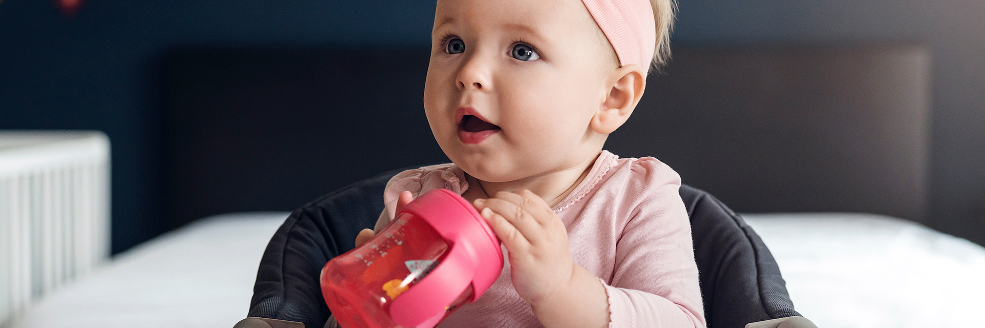 Little girl holding sippy cup