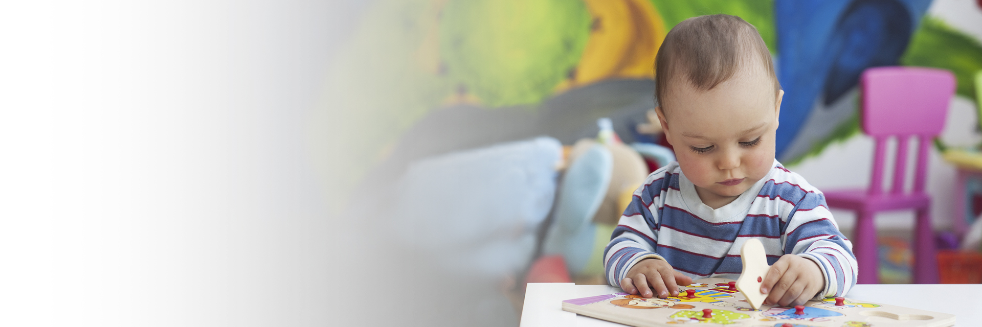 Little boy playing with puzzle pieces on a table