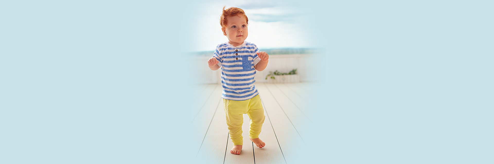 Baby by in stripe shirt walking