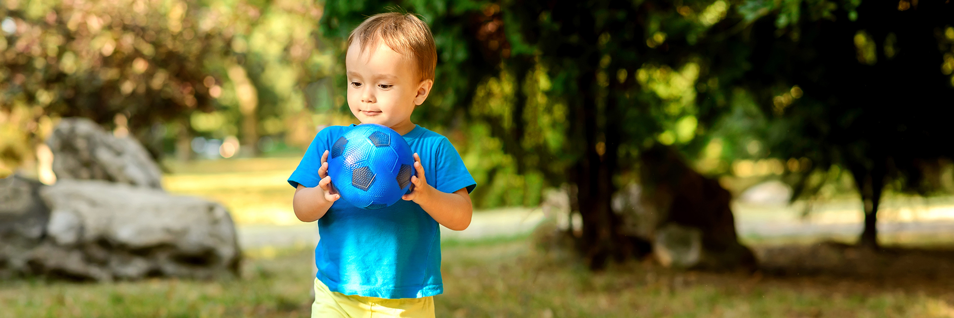 Little boy outside holding ball