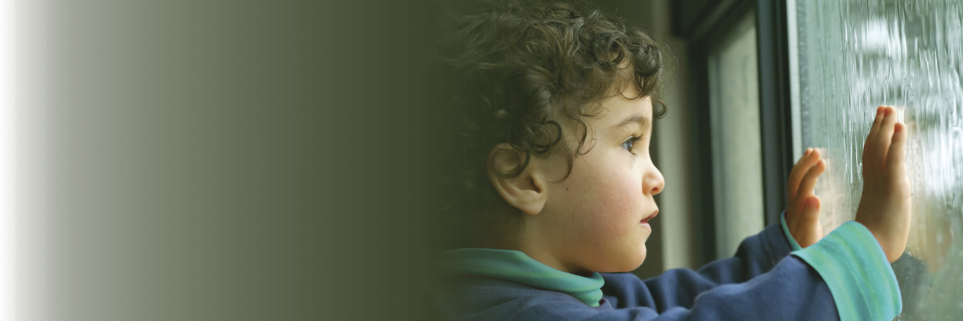 Boy with hands pressed against a window