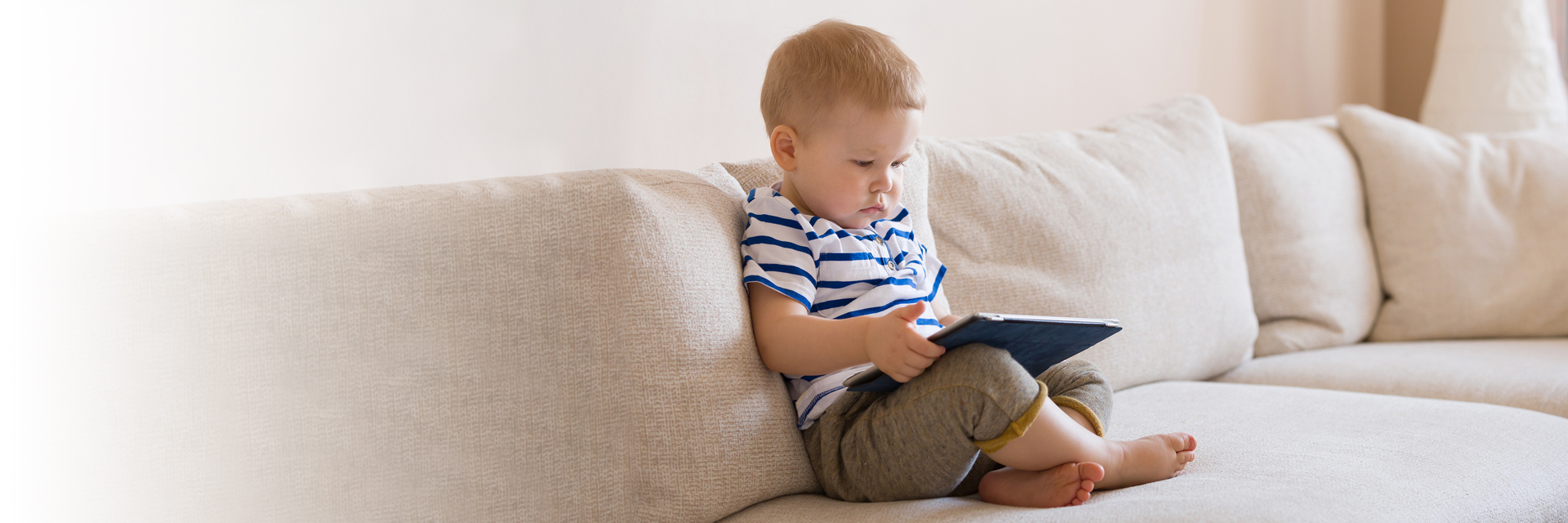 Little boy reading on couch
