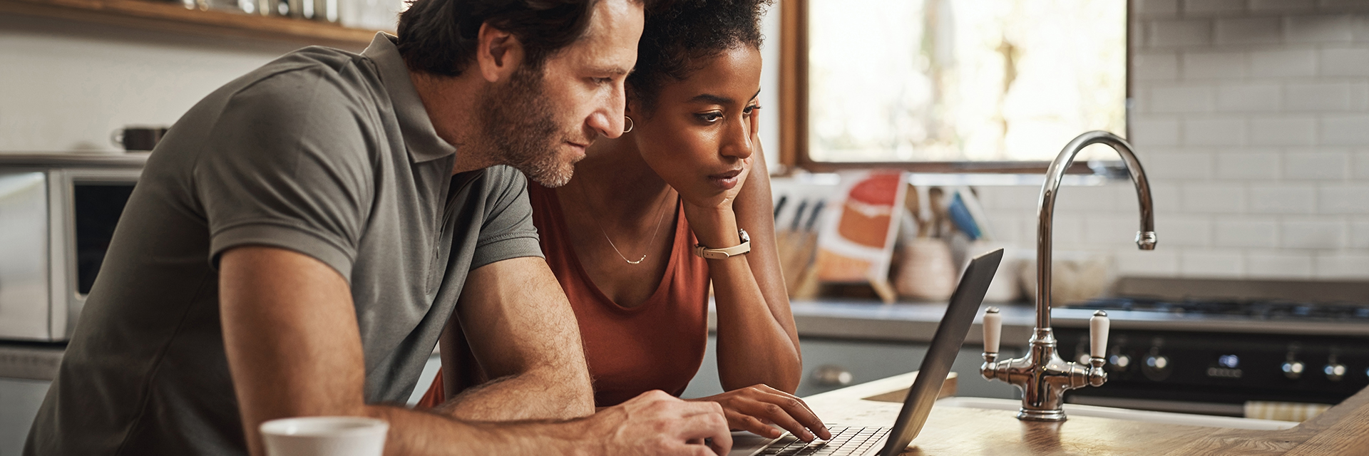 Man and woman on laptop in kitchen