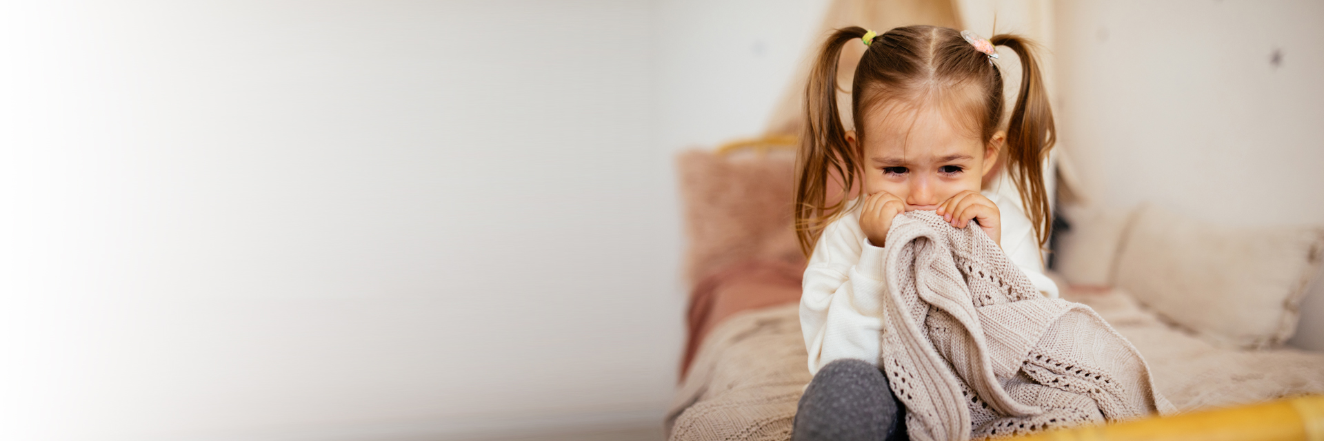 Little girl crying with blanket
