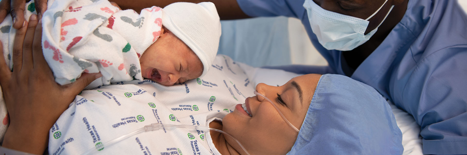 Newborn crying with smiling mom and dad