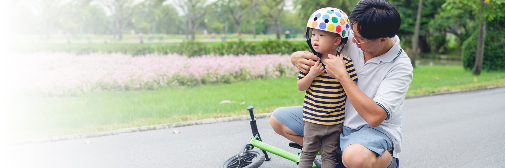 Dad putting on helmet for little boy