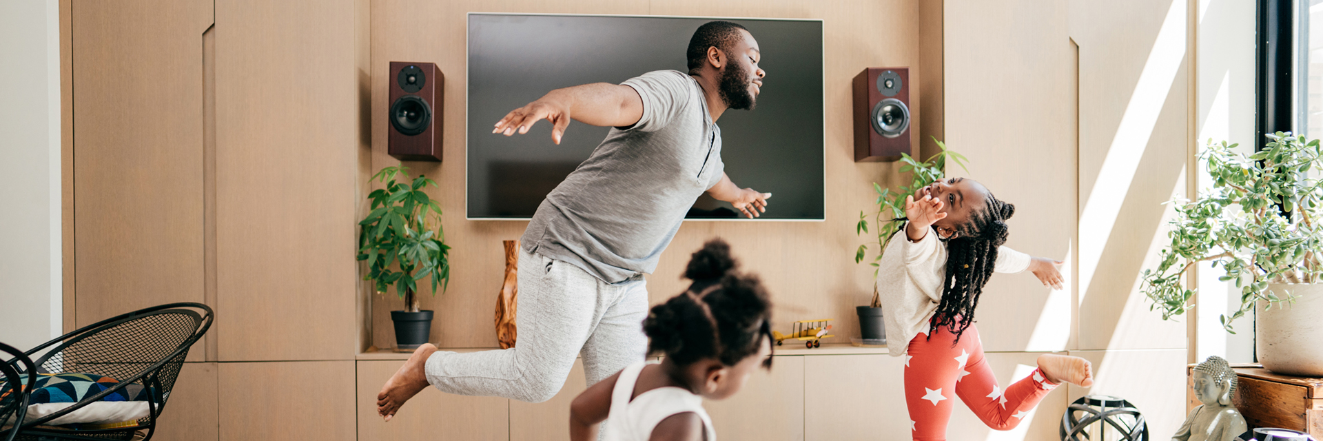 Dad and daughters dancing in living room