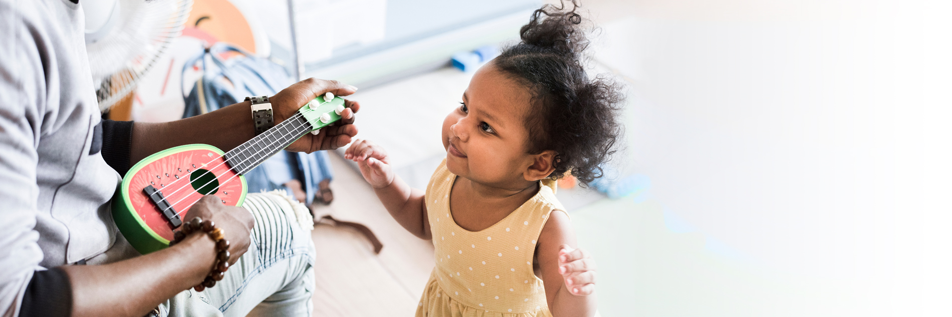Dad playing guitar for little girl