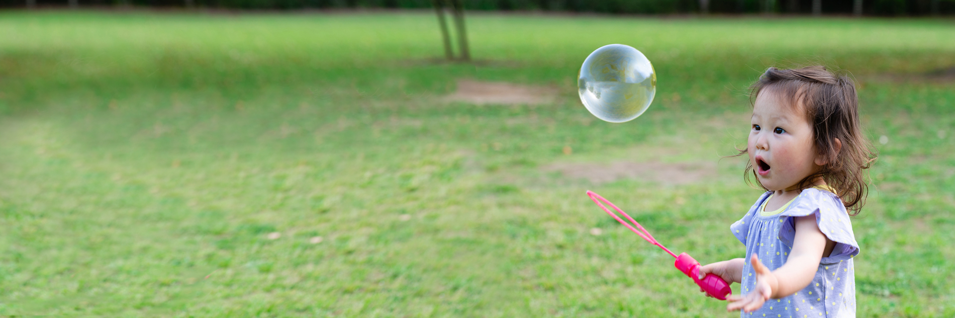 Little girl blowing bubbles outdoors