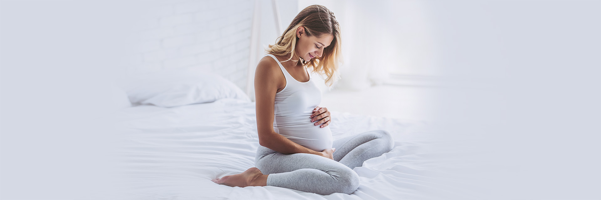 Happy mom to be holding her stomach sitting