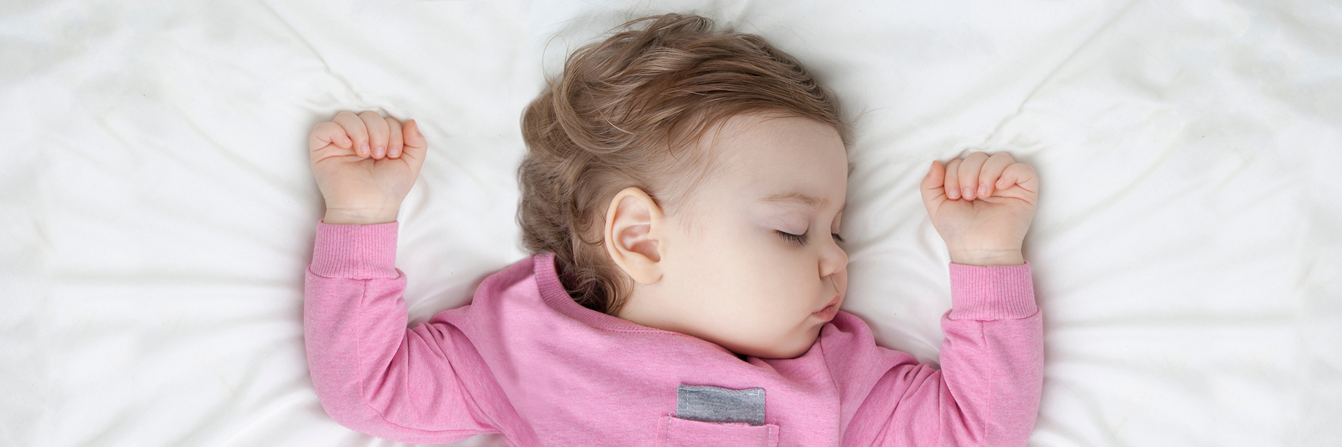 Baby sleeping on back in bed
