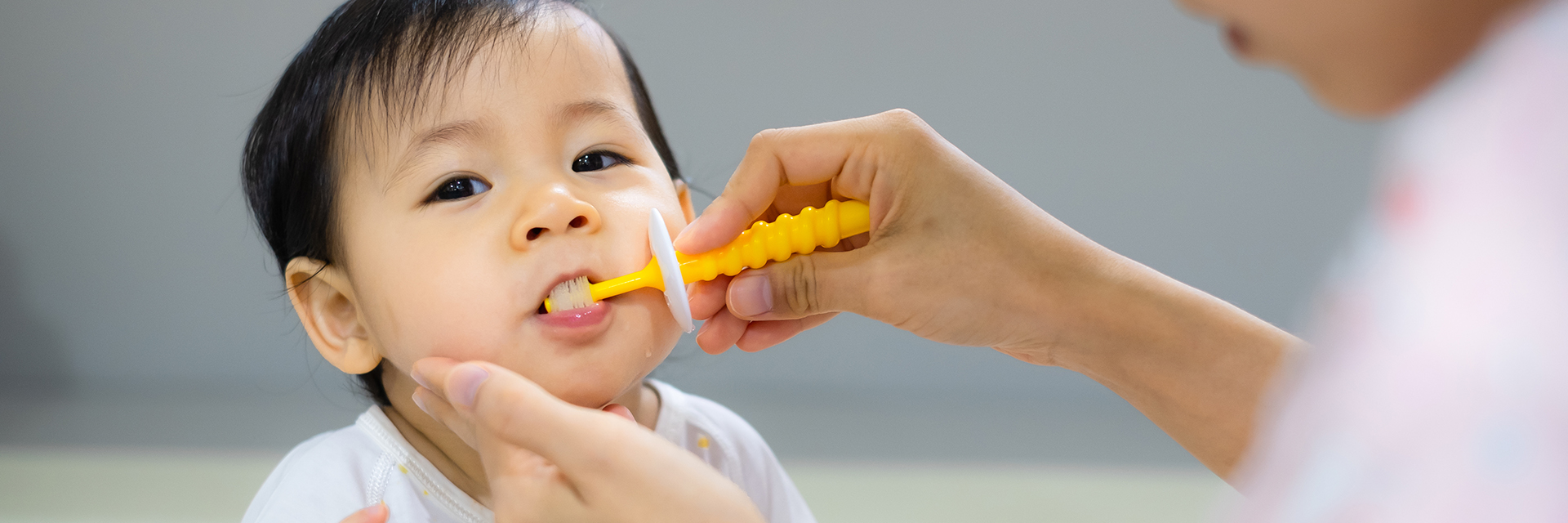Adult brushing little boys teeth