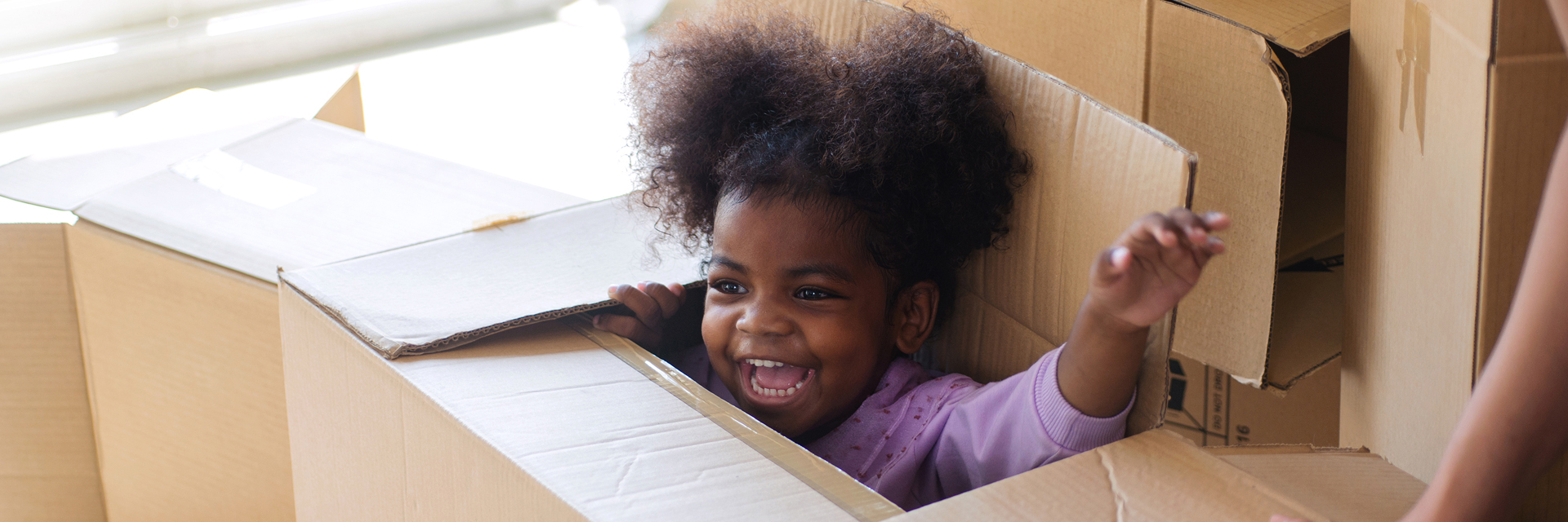 Little girl playing in empty box