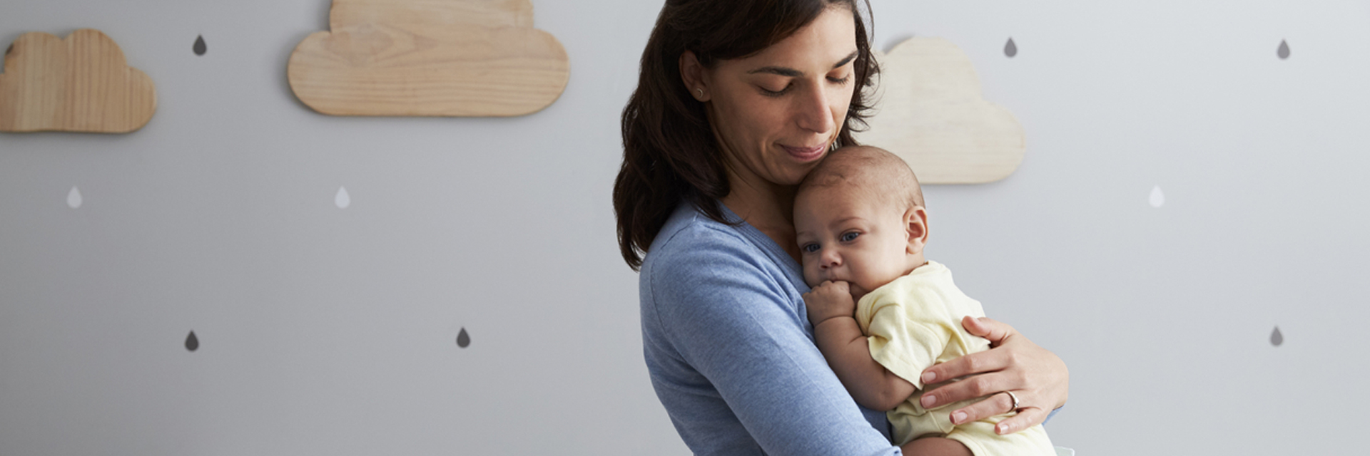 Mom standing holding baby in nursery 