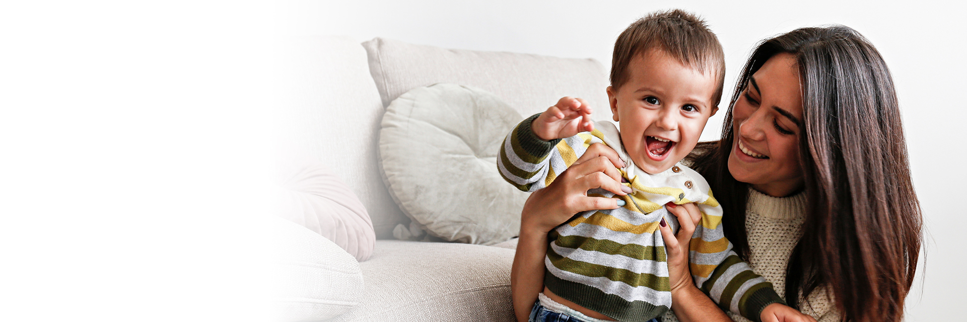 Mom and infant play near sofa