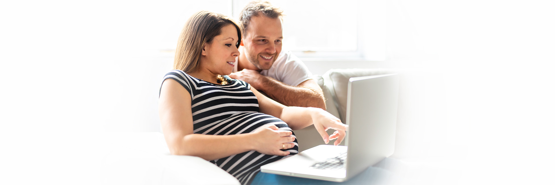 Happy couple looking at laptop