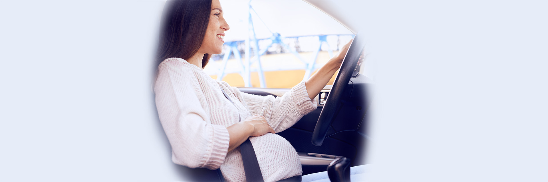 Mom to be driving and holding stomach