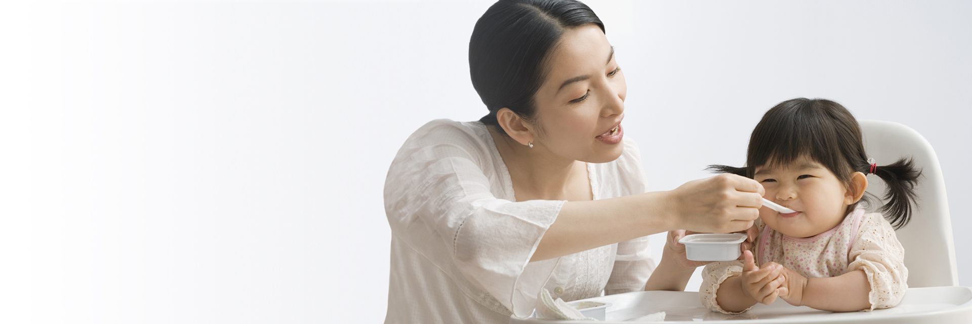 Mom feeding child in high chair
