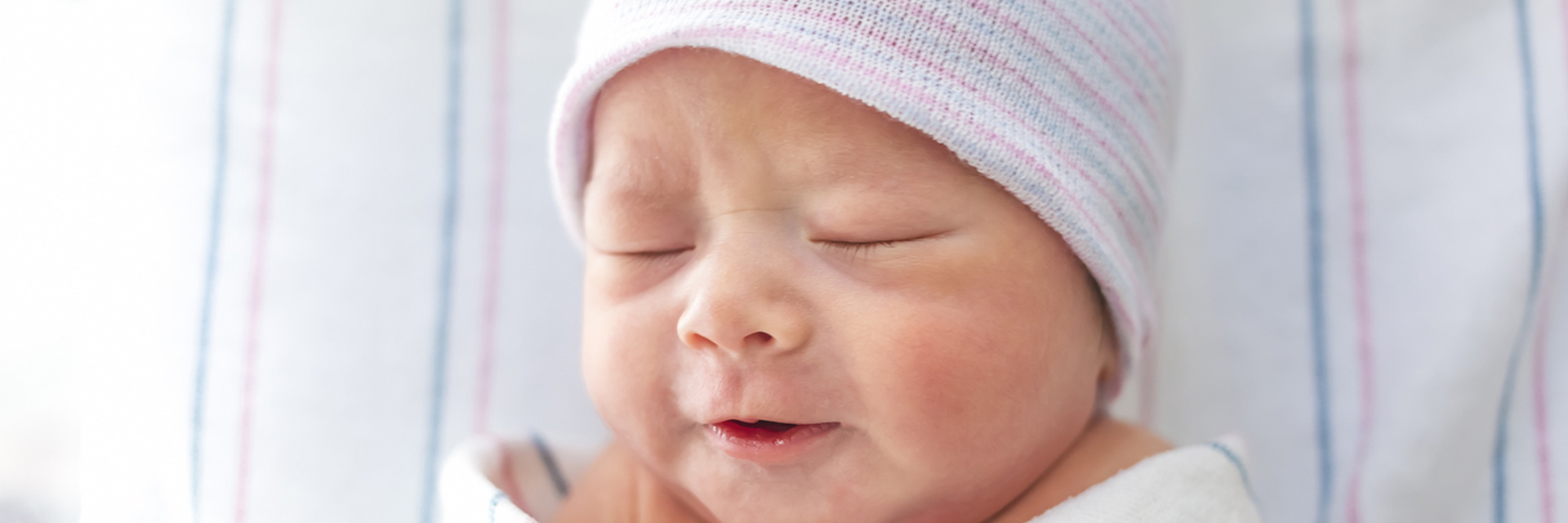 Infant in hat with eyes closed