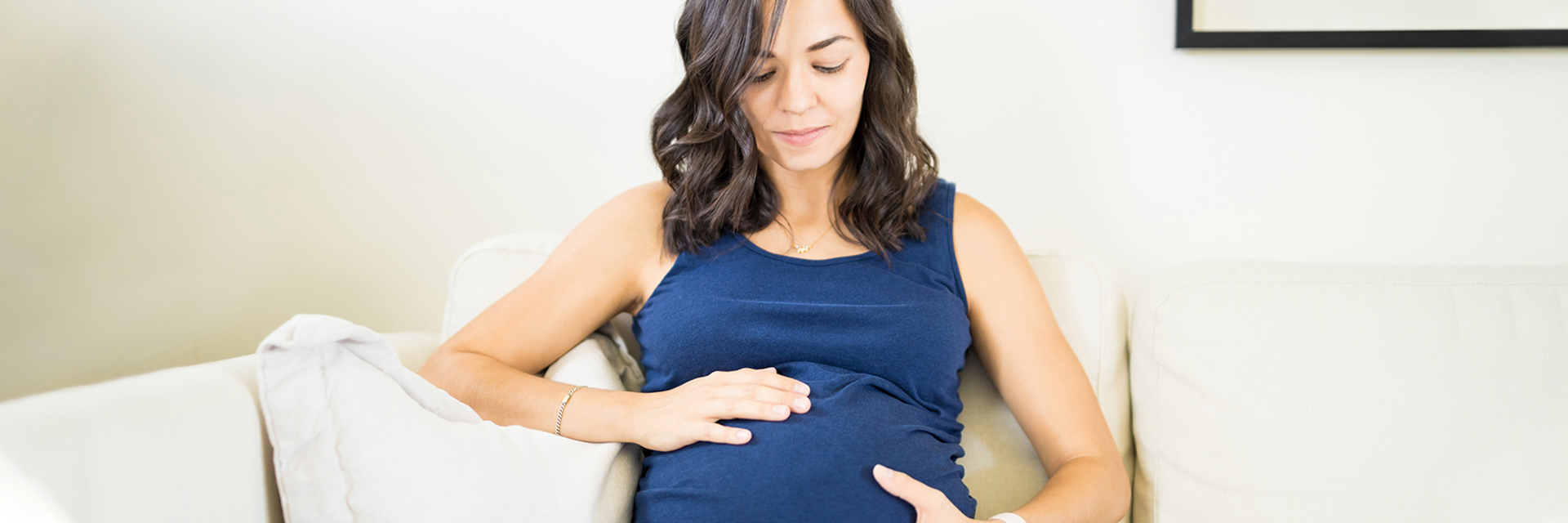 Woman on couch holding stomach