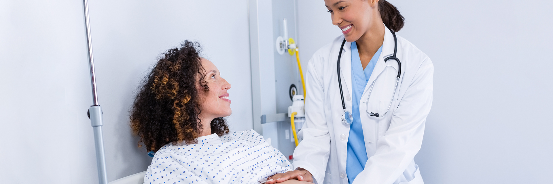 Woman on exam table smiling at her doctor