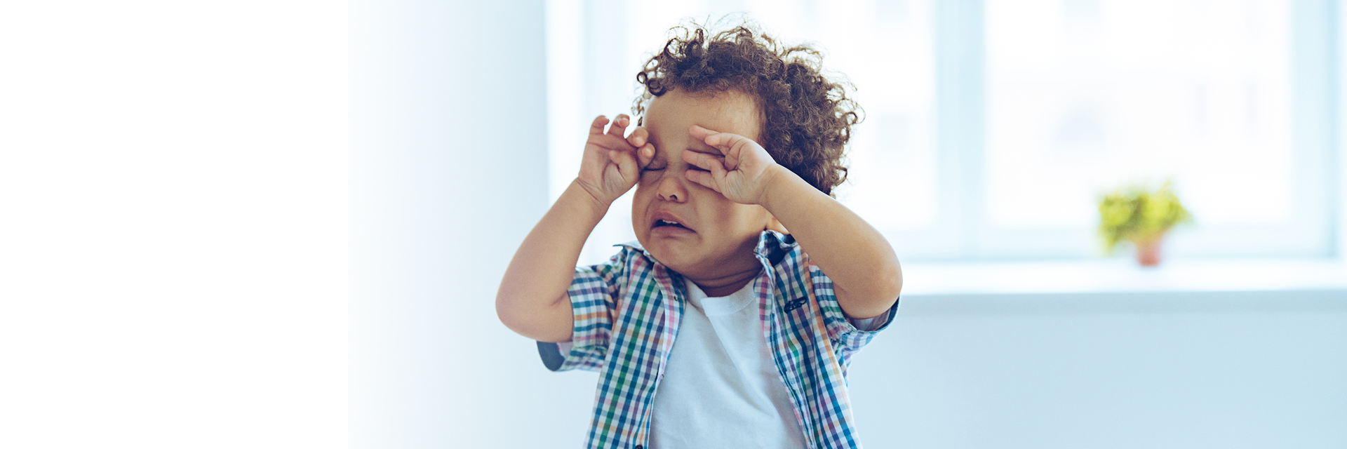 Sleepy infant rubbing eyes