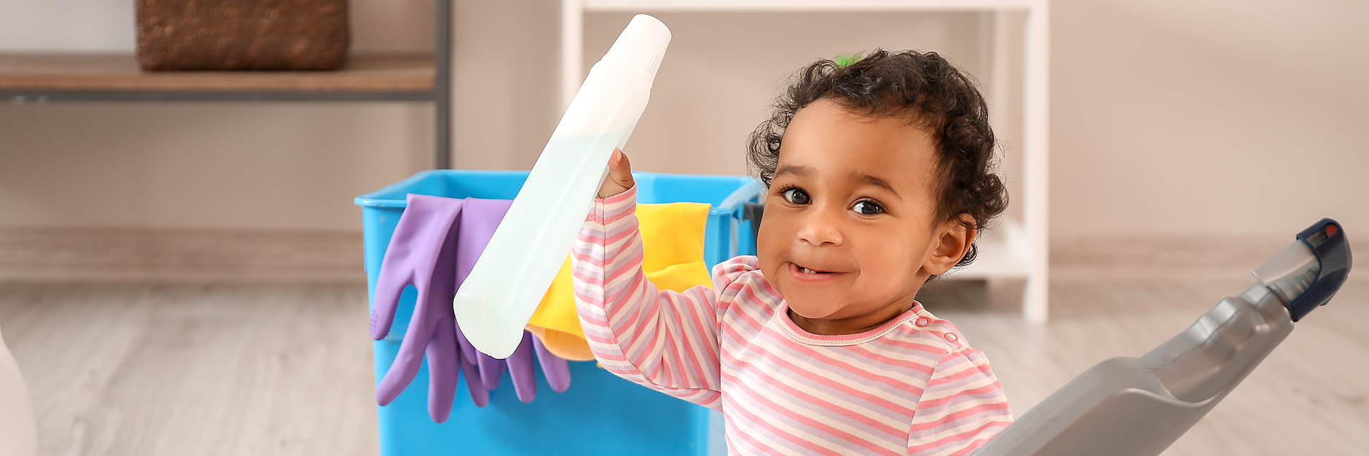 Toddler holding cleaning bottles