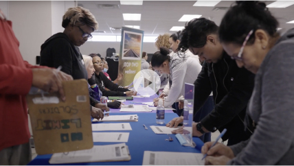 Many people in a room filling out forms