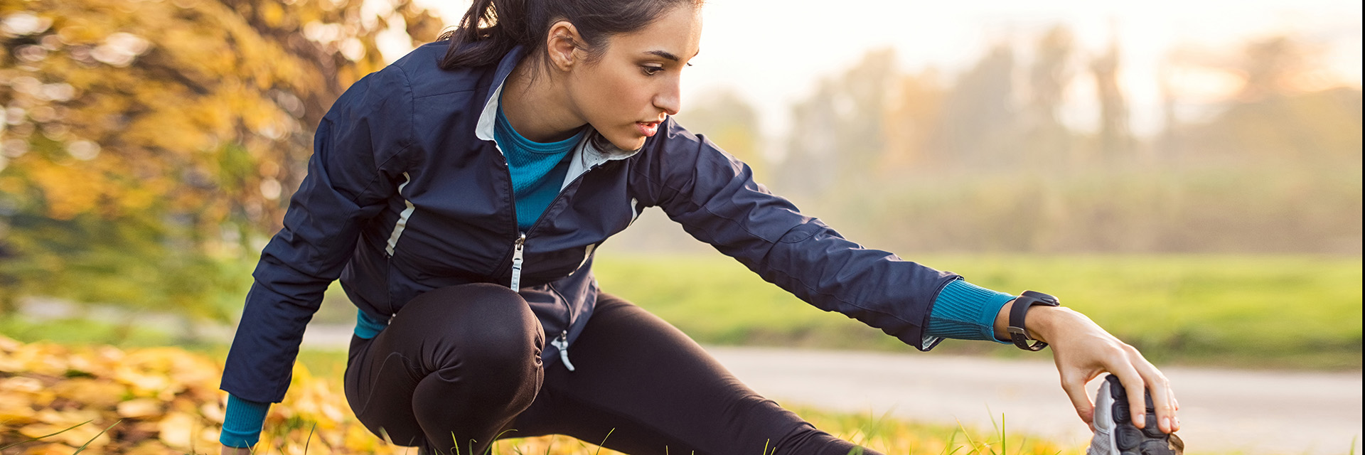 Female in a jacket stretching outdoors
