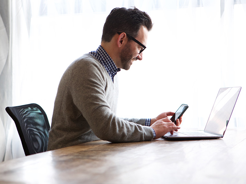 Man on laptop and phone