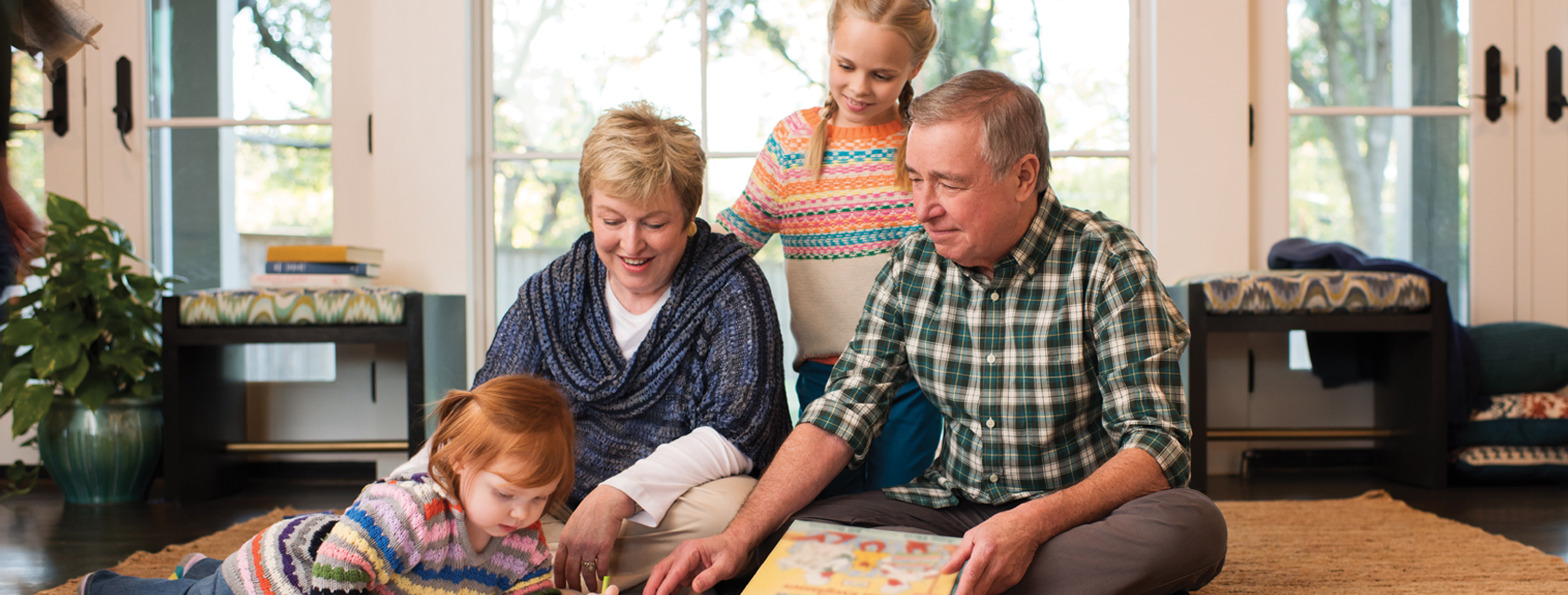 Grand parents sitting on ground with grandchild